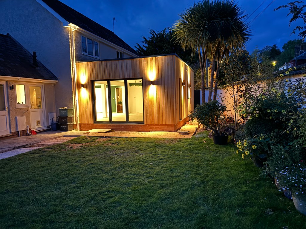 Cedar-clad extension lit up at night